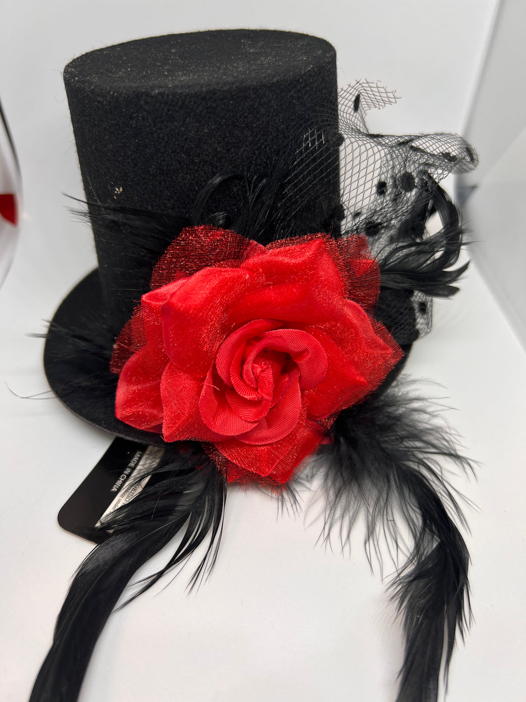 Black hat pin with red tosses and black feather